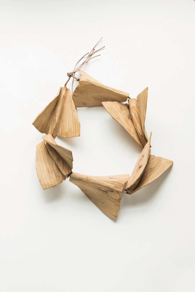 Eine Holzkette aus vielen Holzteilen, die aussehen wie kleine Papierflieger