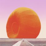 Eine lange, gerade Straße mit einem kleinen Auto, im Hintergrung ist ein großer orangefarbener Autoreifen zu sehen, so dass es aussieht, also ob das Auto vor einem Sonnenuntergang fährt.